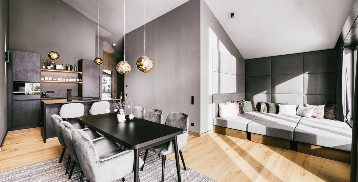 Bright living and dining area with kitchen in the 2 Bedroom Deluxe Suite at the TRIFORÊT alpin.resort in Hinterstoder.