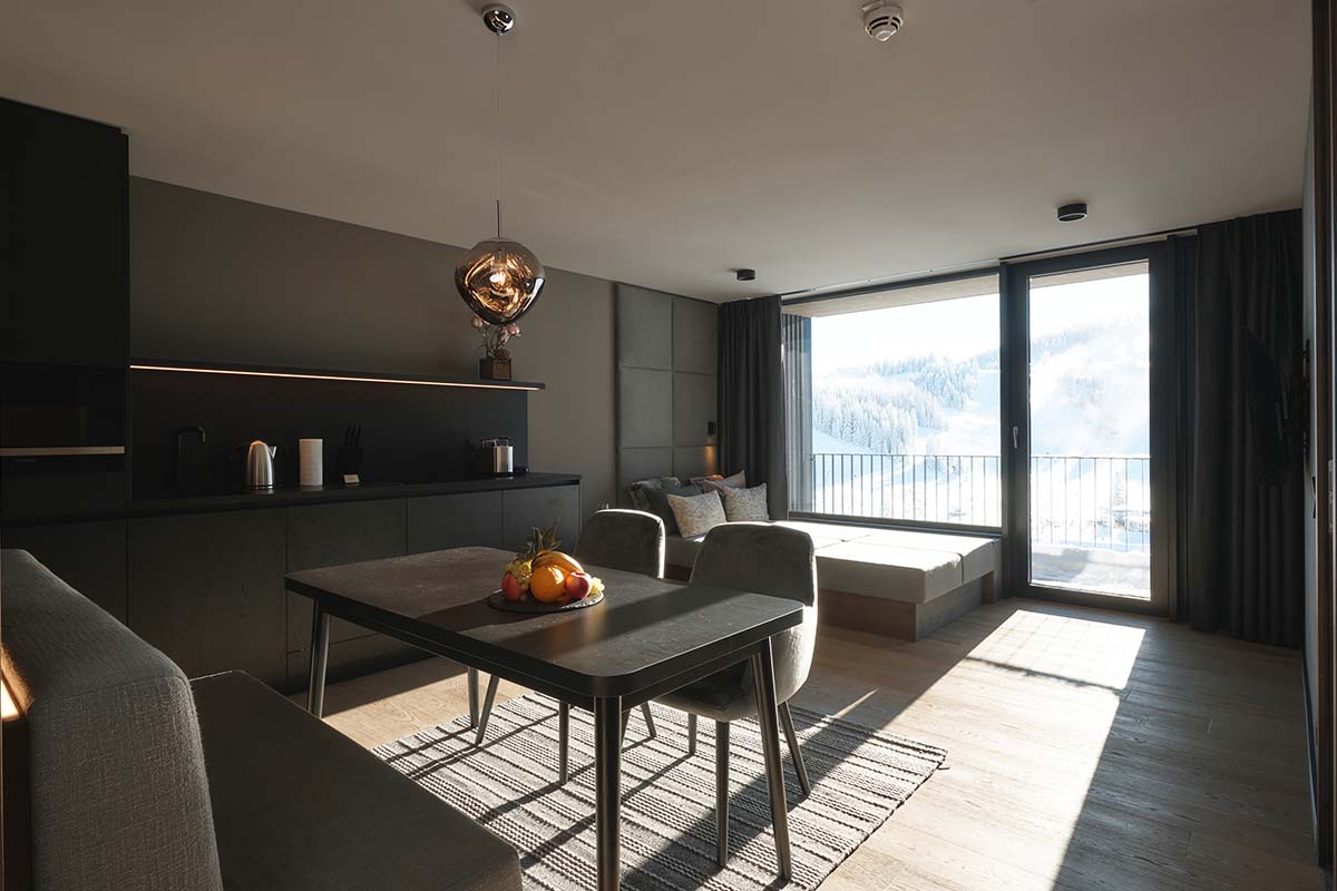 Viel Platz für große Gefühle – Familienhotelzimmer mit Küche im TRIFORÊT alpin.resort, umgeben von den Bergen.