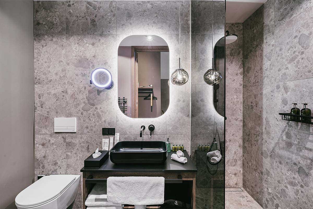 Stylish bathroom with walk-in shower in the “Kleiner Priel” 1 Bedroom Suite at the TRIFORÊT alpin.resort in Hinterstoder.