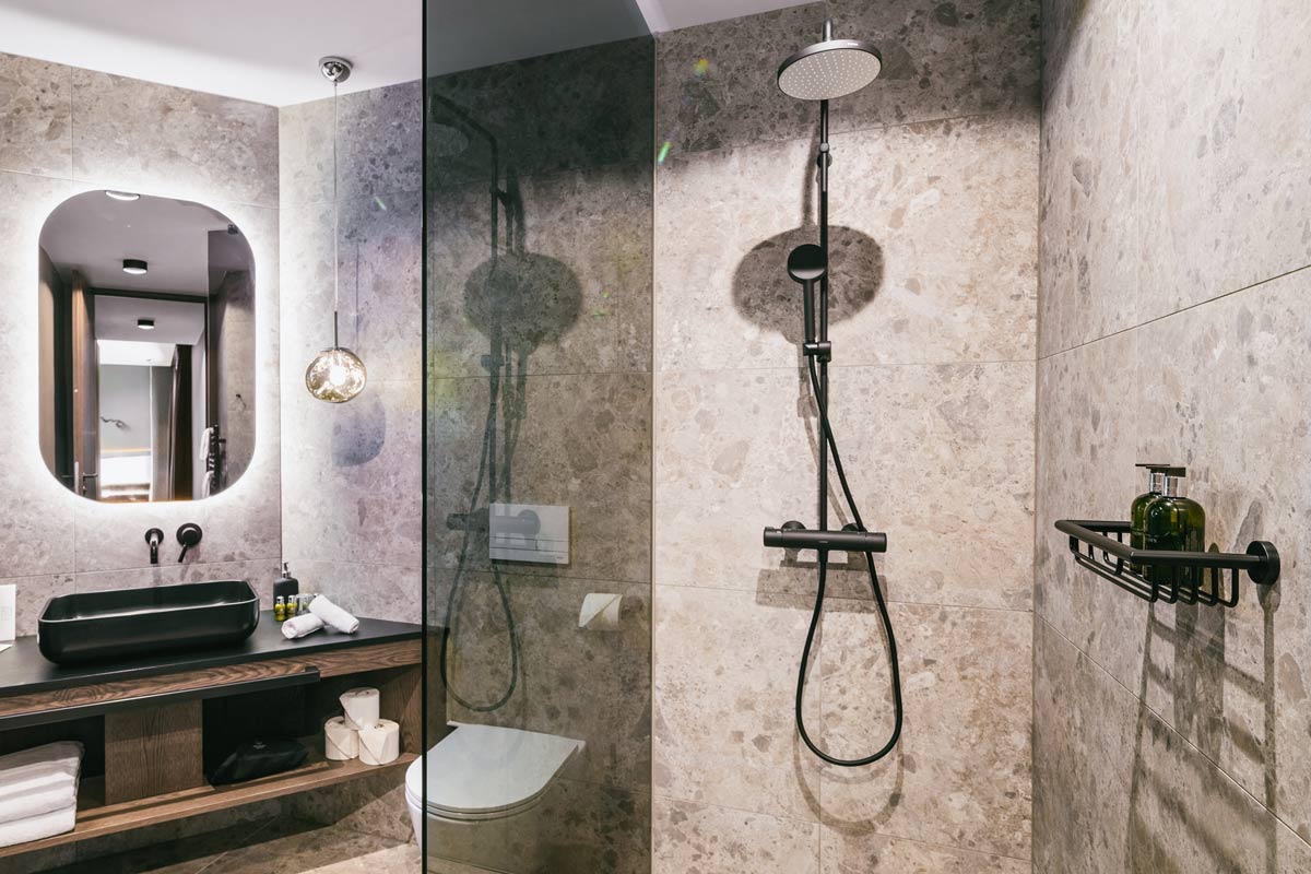 Bathroom with walk-in shower in the 2 Bedroom Deluxe Suite “Hösskogel” at the Triforêt alpin.resort in Hinterstoder.