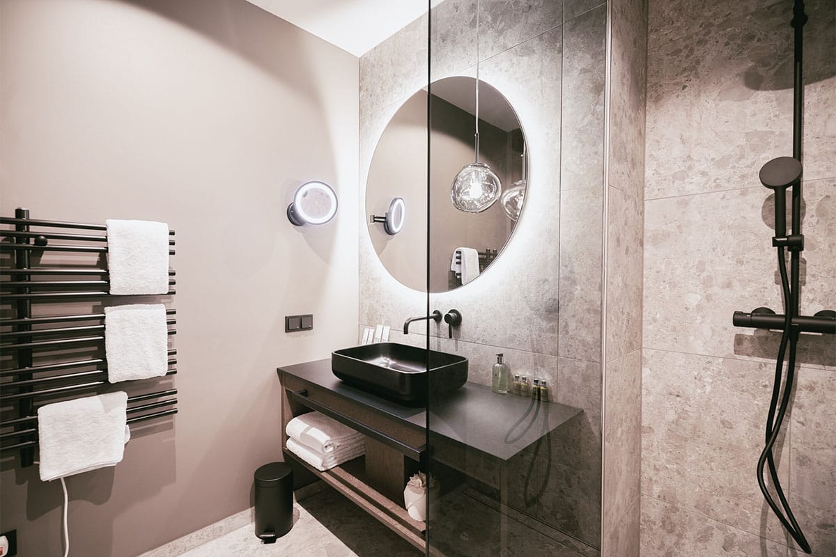 Stylish bathroom with spacious shower and washstand in the Family Suite “Schafkogel” at the Triforêt alpin.resort.