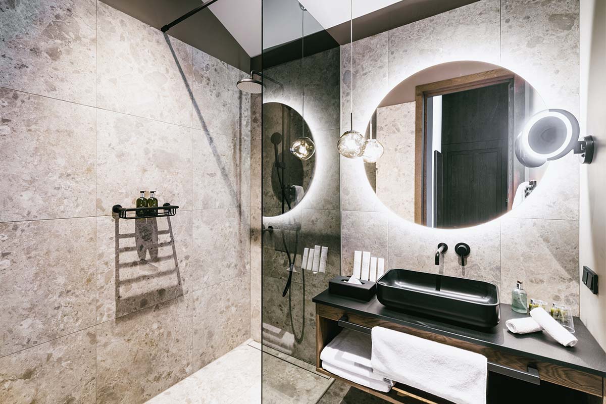 Walk-in shower in the bathroom of the 3 Bedroom Deluxe Suite “Hösskogel” at the Triforêt alpin.resort in Hinterstoder.