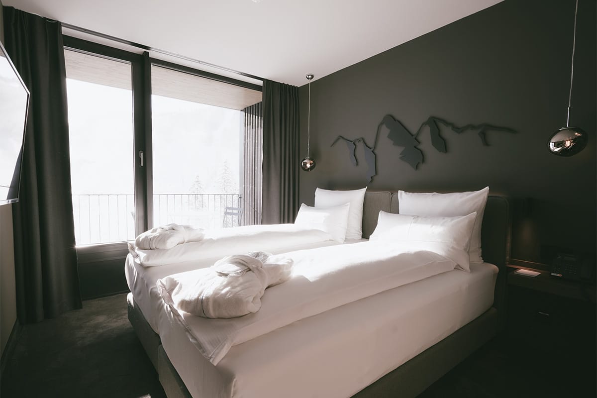 Cosy double bed in the 1 Bedroom Superior Suite “Almkogel” at the TRIFORÊT alpin.resort in Hinterstoder.