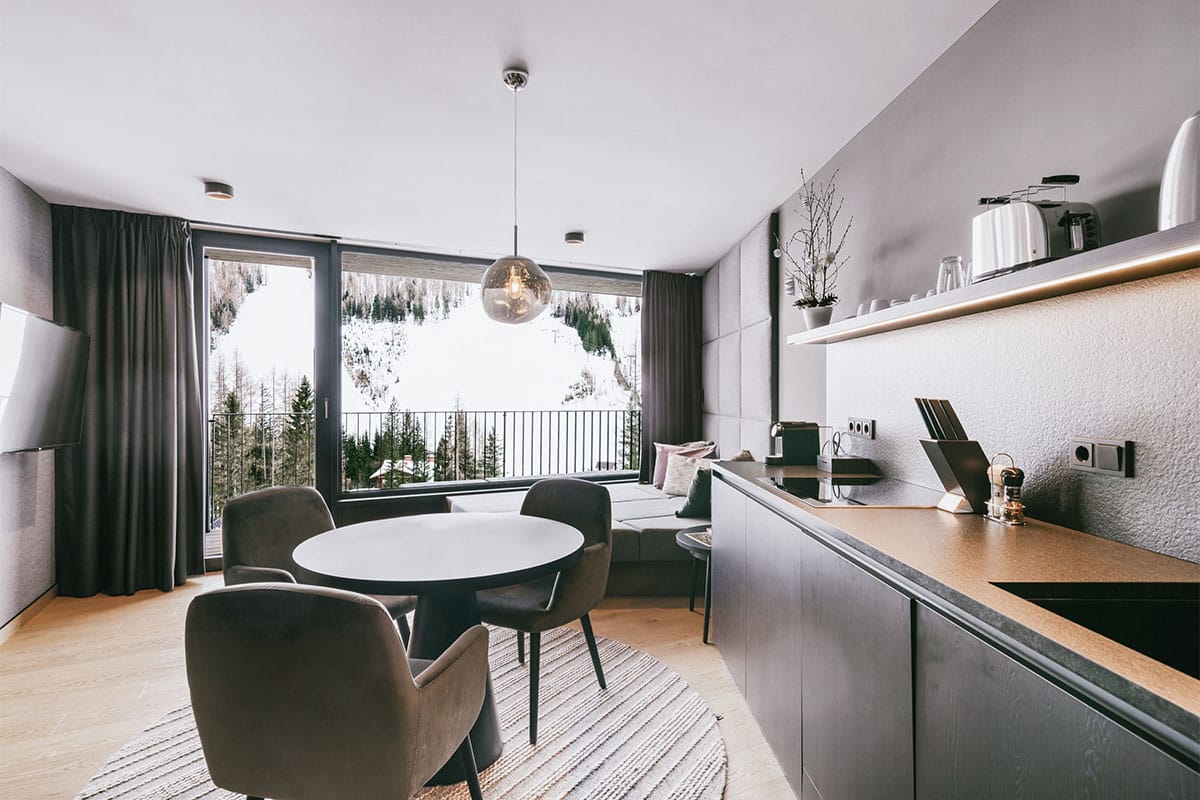 Kitchen and living area of the 1 Bedroom Superior Suite “Almkogel” at the TRIFORÊT alpin.resort in Hinterstoder.