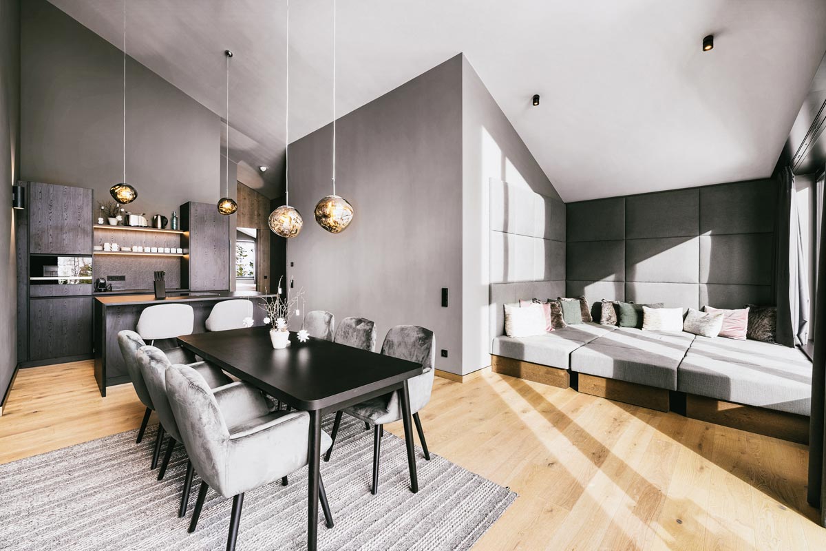 Bright living and dining area with kitchen in the 2 Bedroom Deluxe Suite at the TRIFORÊT alpin.resort in Hinterstoder.