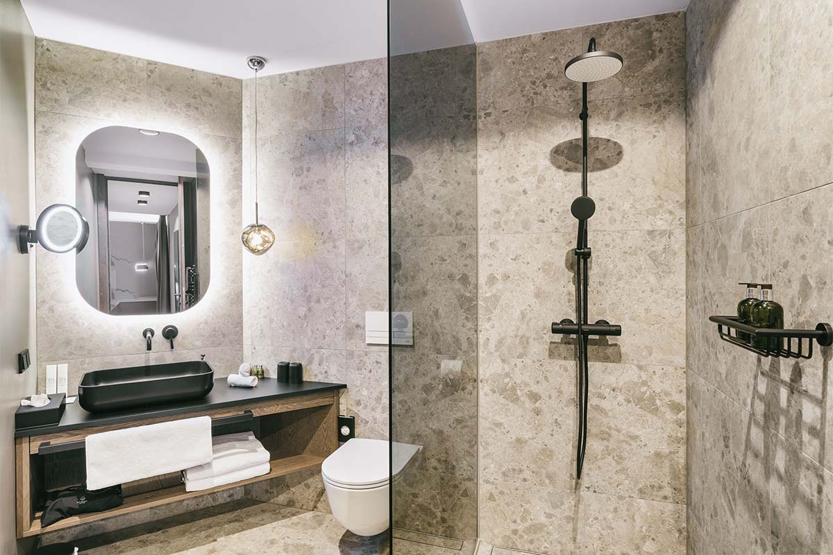 Bathroom with shower and washstand in the studio apartment “Warscheneck” at the TRIFORÊT alpin.resort in Hinterstoder.