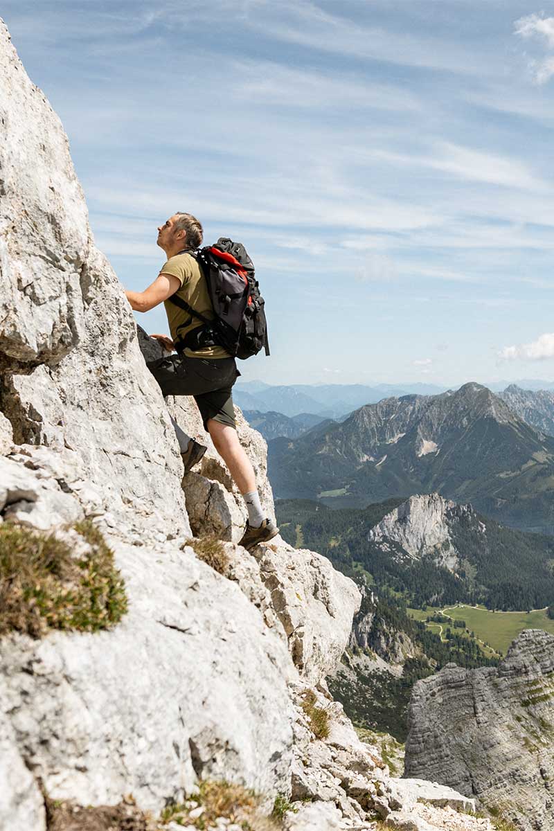 Ein Mann auf Klettertour in den Bergen in Hinterstoder im Sommerurlaub im TRIFORÊT alpin.resort.