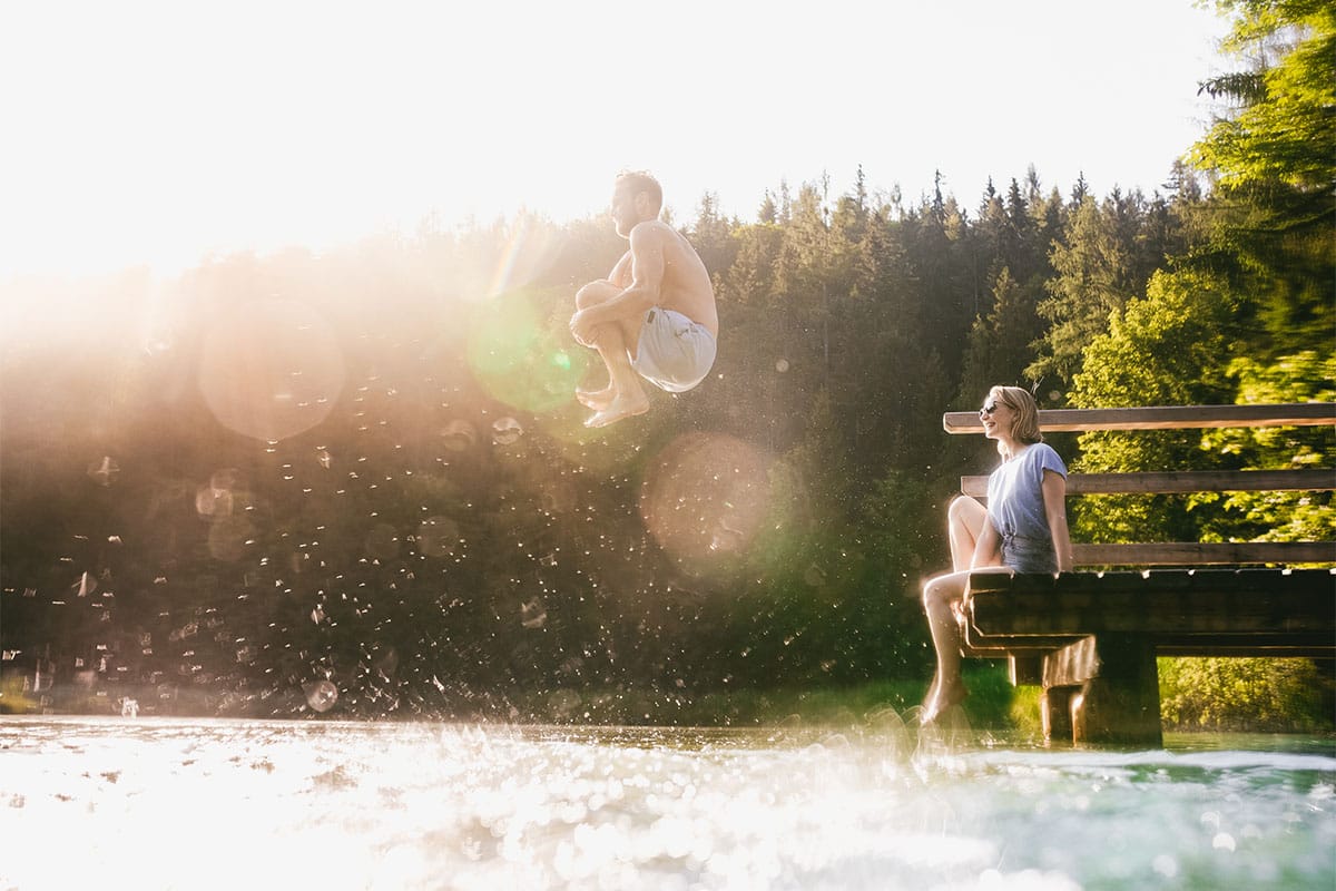 Sprung ins kühle Nass bei Sonnenschein am Schafferteich im Sommerurlaub im TRIFORÊT alpin.resort.