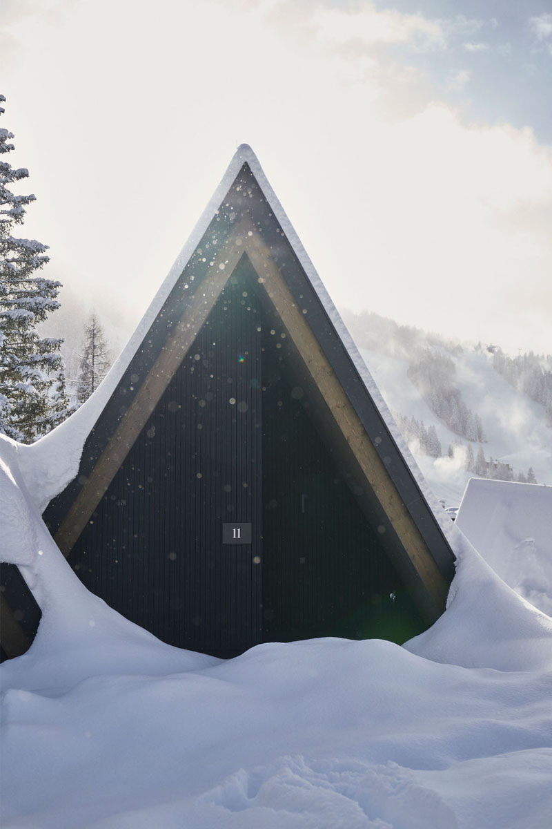 Unser Chalet im Schneeparadies Hinterstoder erwartet Sie. Schneebedecktes Design-Chalet mit klarer Geometrie und winterlicher Stimmung im TRIFORÊT alpin.resort in Hinterstoder.