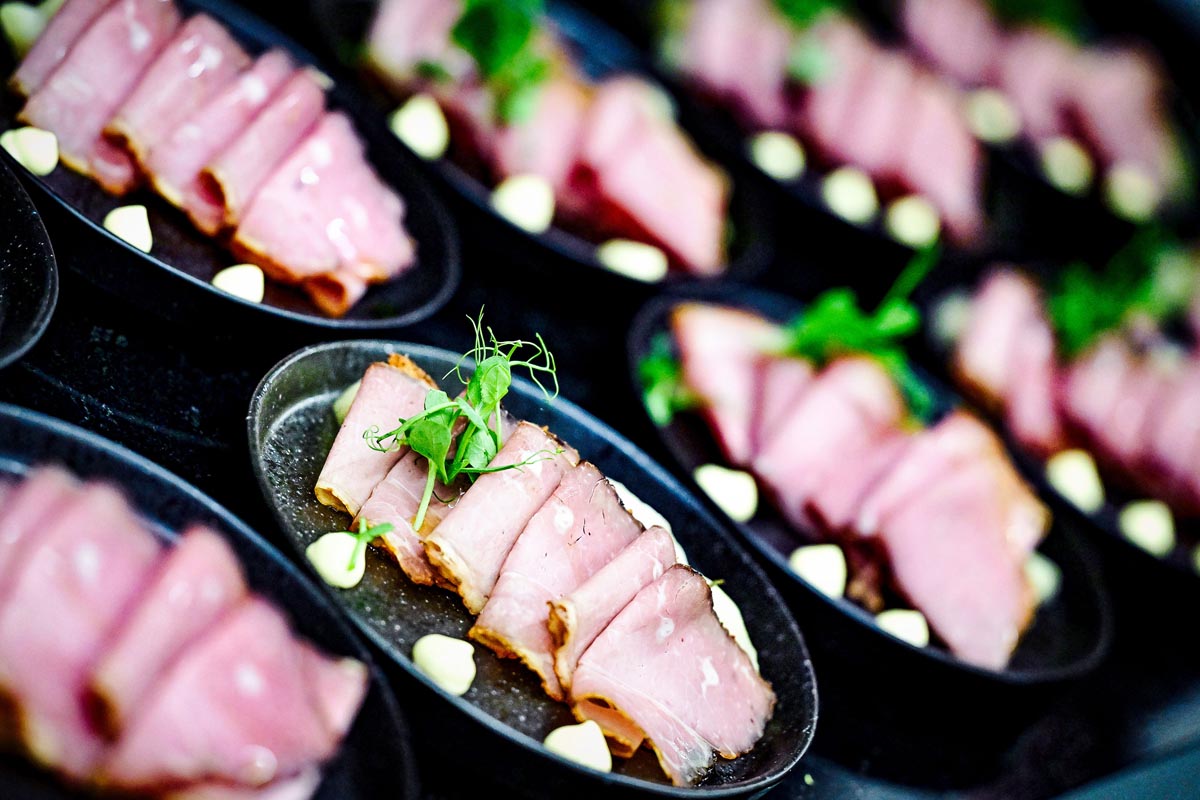Close-up of an elegantly arranged meat dish on a dark plate in the Hutterer restaurant at TRIFORÊT alpin.resorts.
